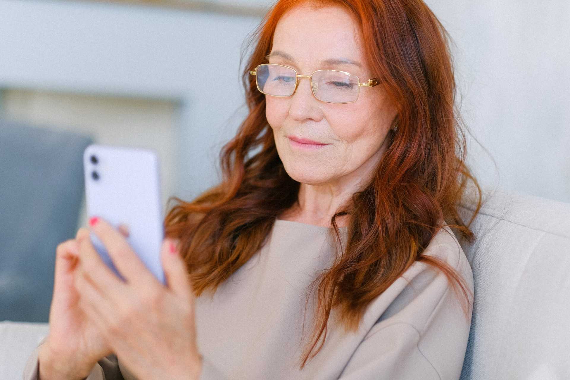 senior woman at home sitting using iphone