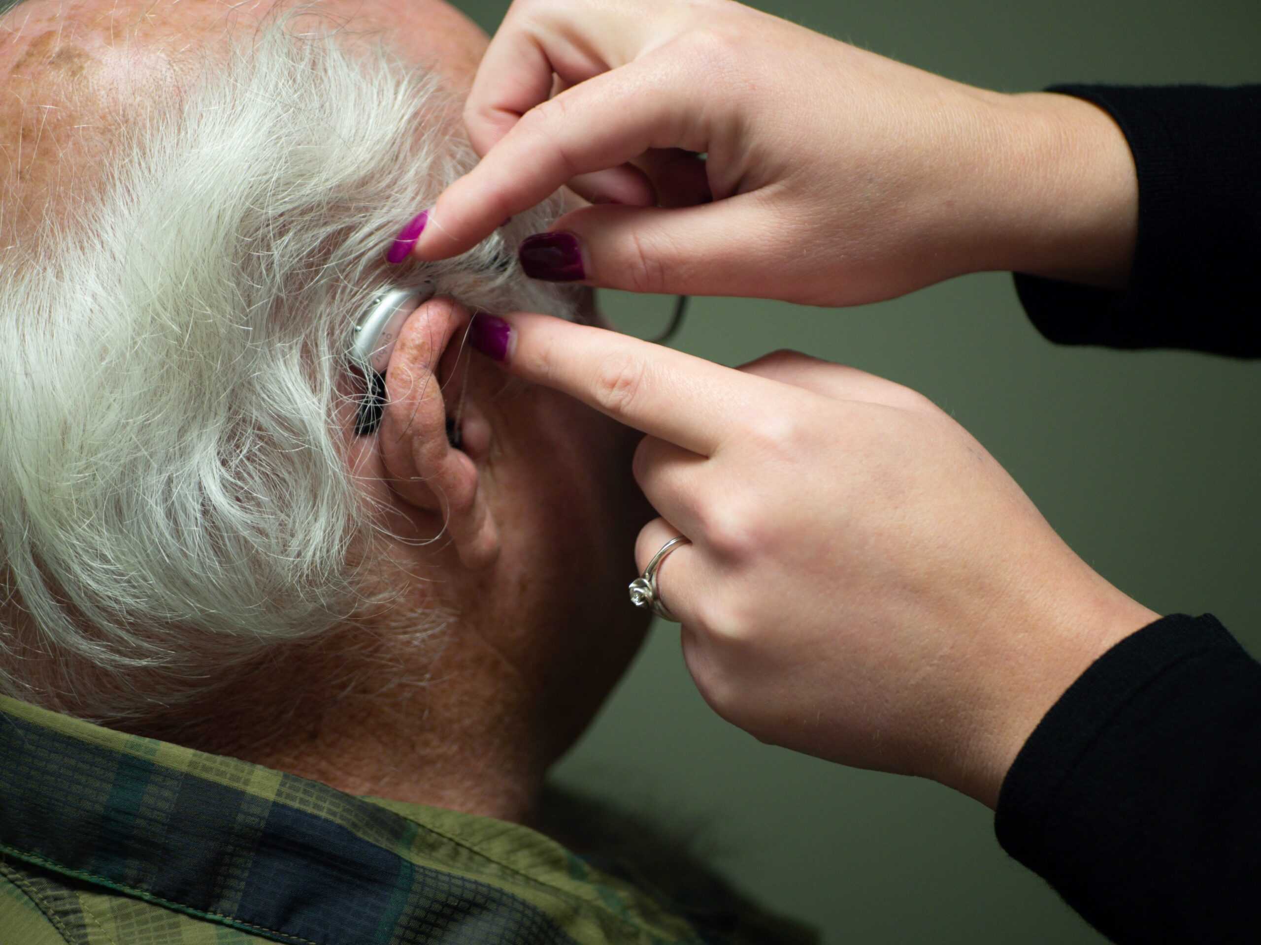 hearing expert helping with hearing aid