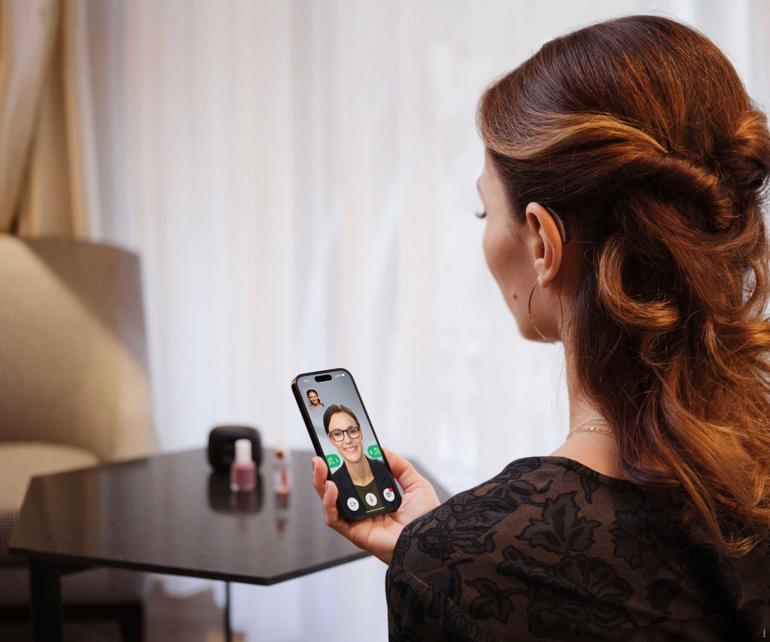 woman holding phone looking at phone at home